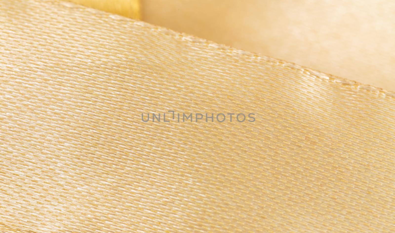 Close up Golden ribbon isolated on white with copy space for text.