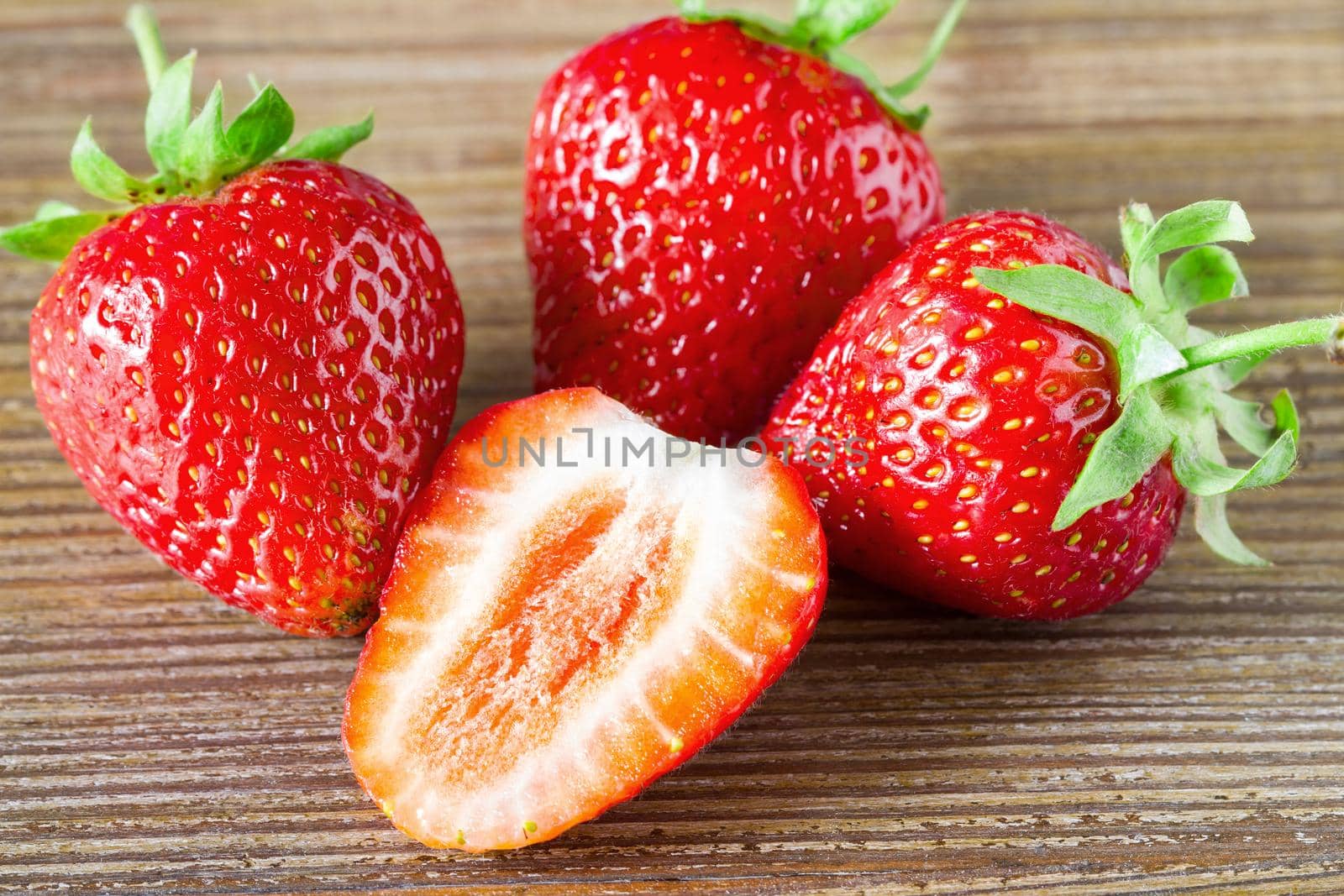 Fresh strawberry close up on the dark wood background