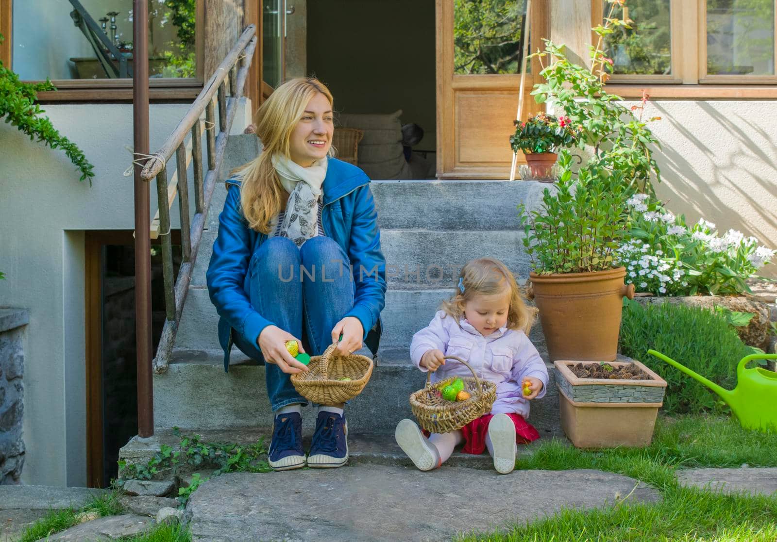 Mother and daughter collecting easter eggs in the garden