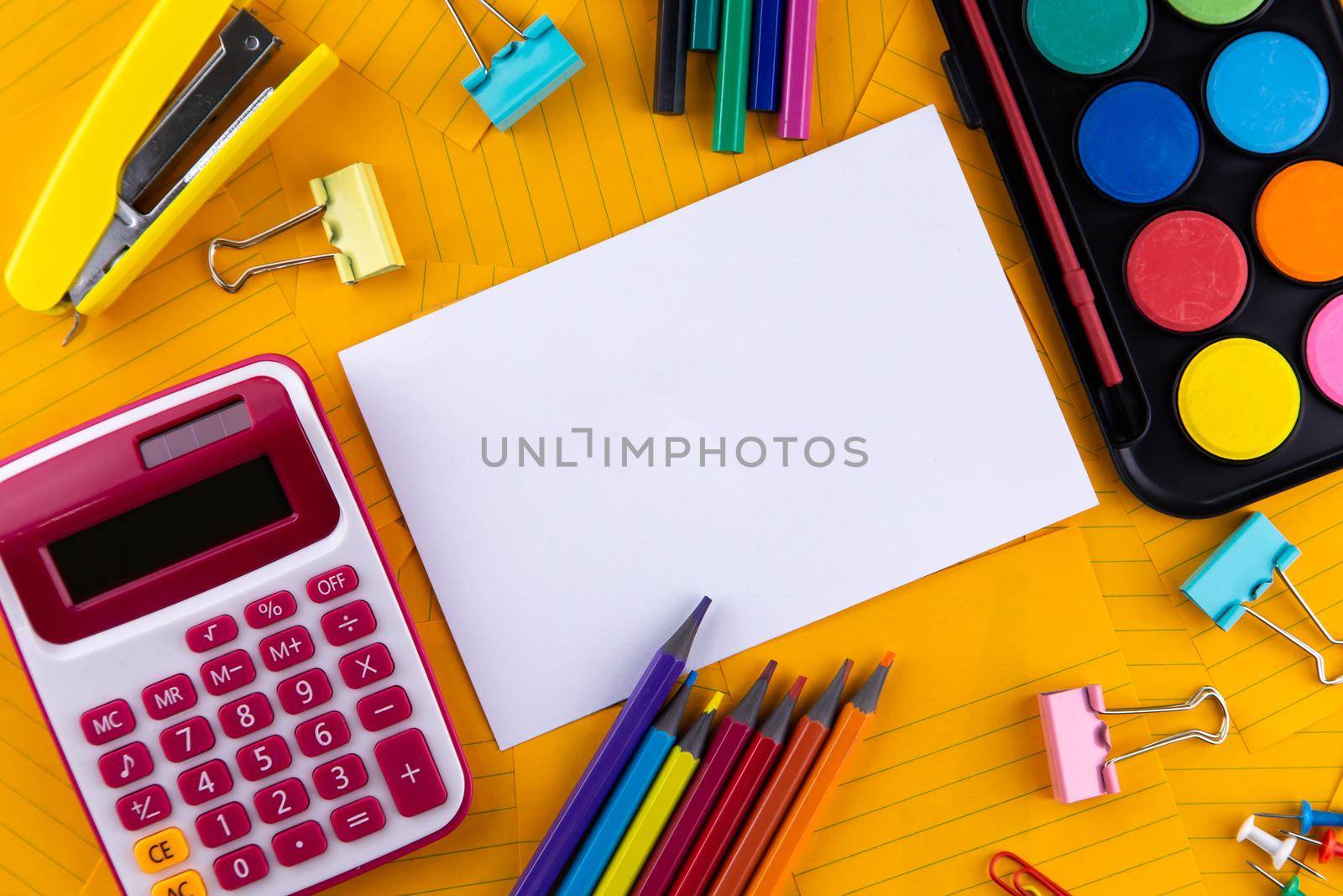 School office supplies stationery on a orange paper background with copy space. Back to school concept.