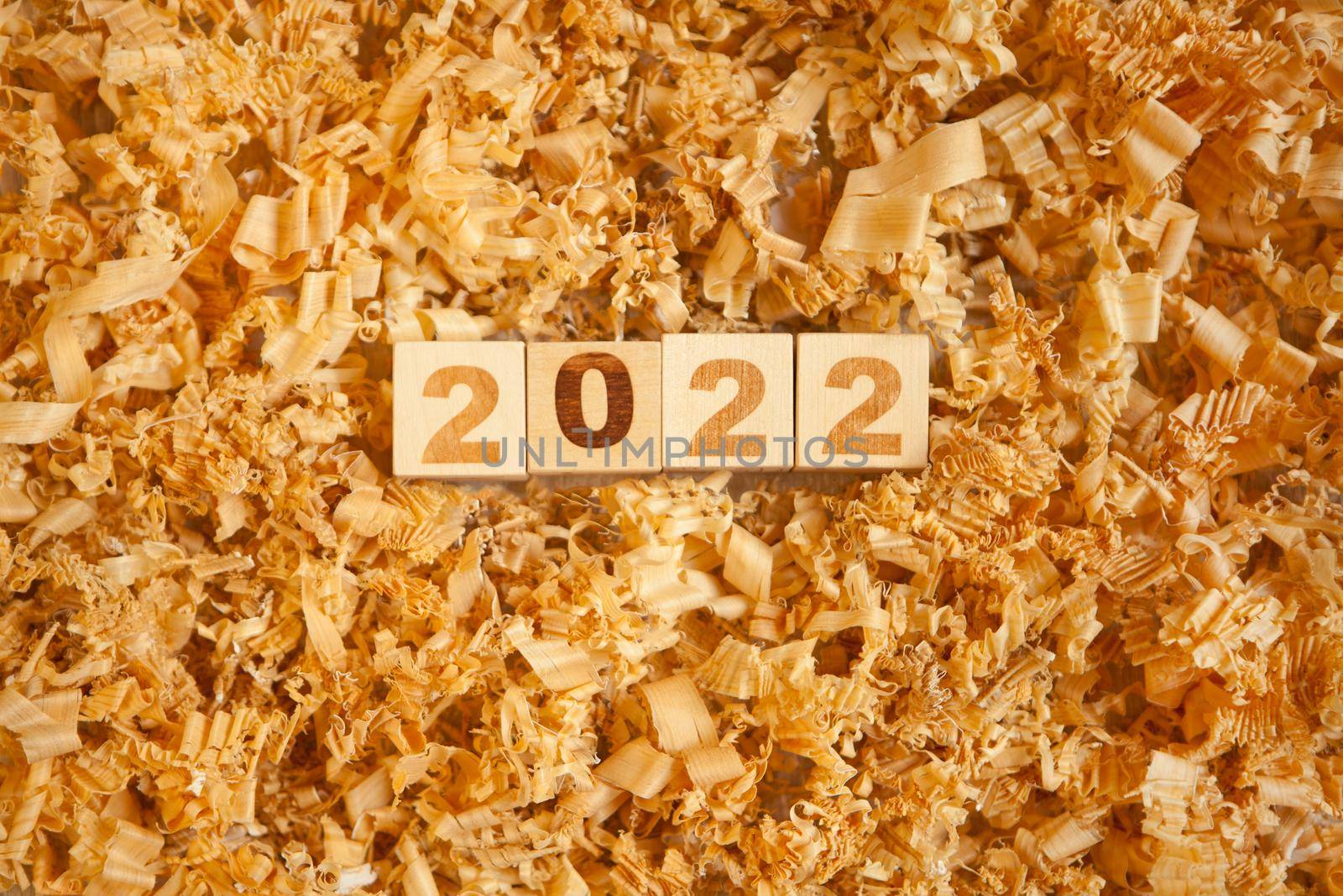 wooden numbers 2022 cubes symbolizng Christmas or new year celebration. wooden toys and timber shavings. brown colors