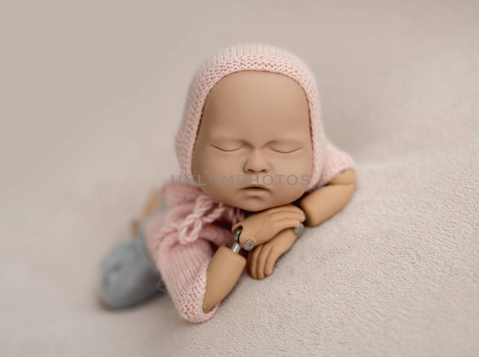 Precisely accurate mannequin of newborn in a knitted suit for photo practicing