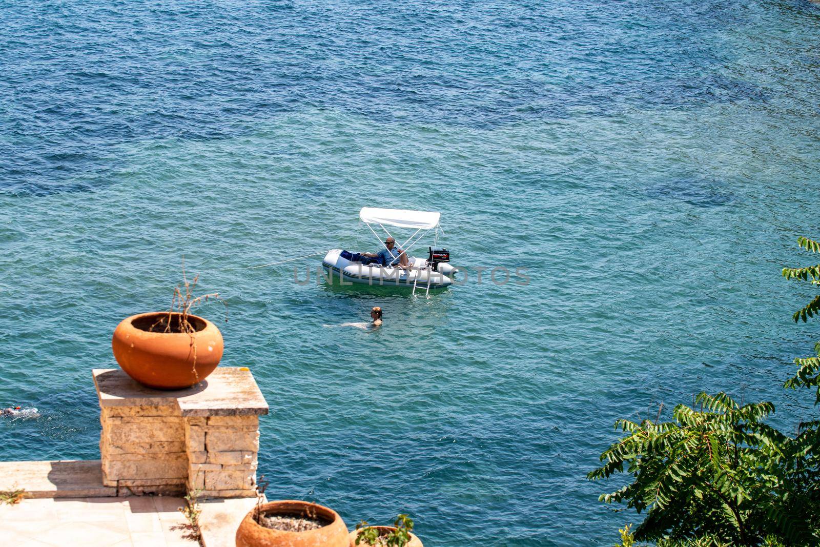 porto santo stefano,italy july 24 2021:small boats on the sea with bathers