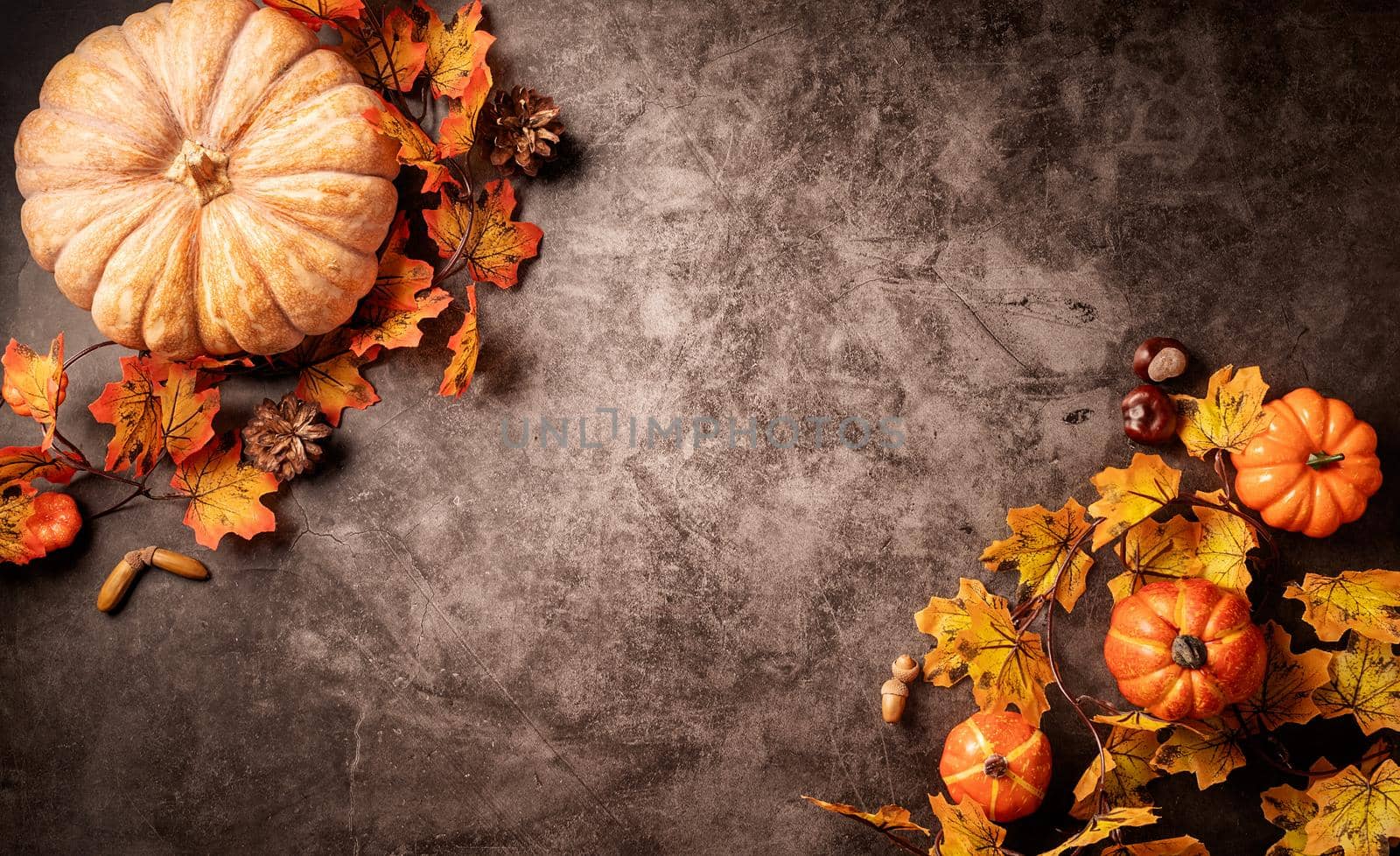Halloween concept. Autumn decorations with pumpkins and leaves top view on black backgound with copy space