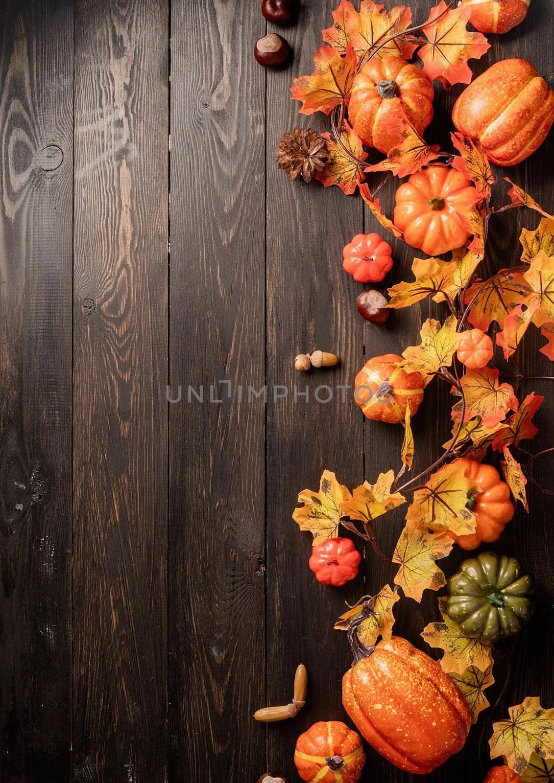 Autumn decorations with pumpkins and leaves top view on black wooden backgound by Desperada