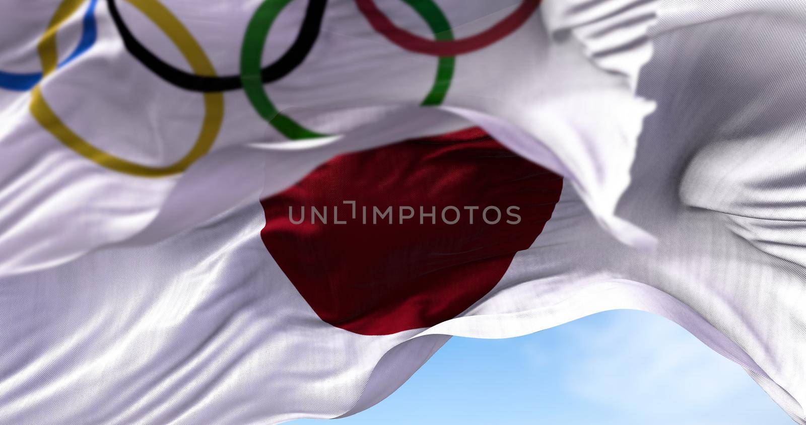 Tokyo, Japan, July 2021: The national flag of Japan waving with the Olympic flag blurred in the foreground by rarrarorro