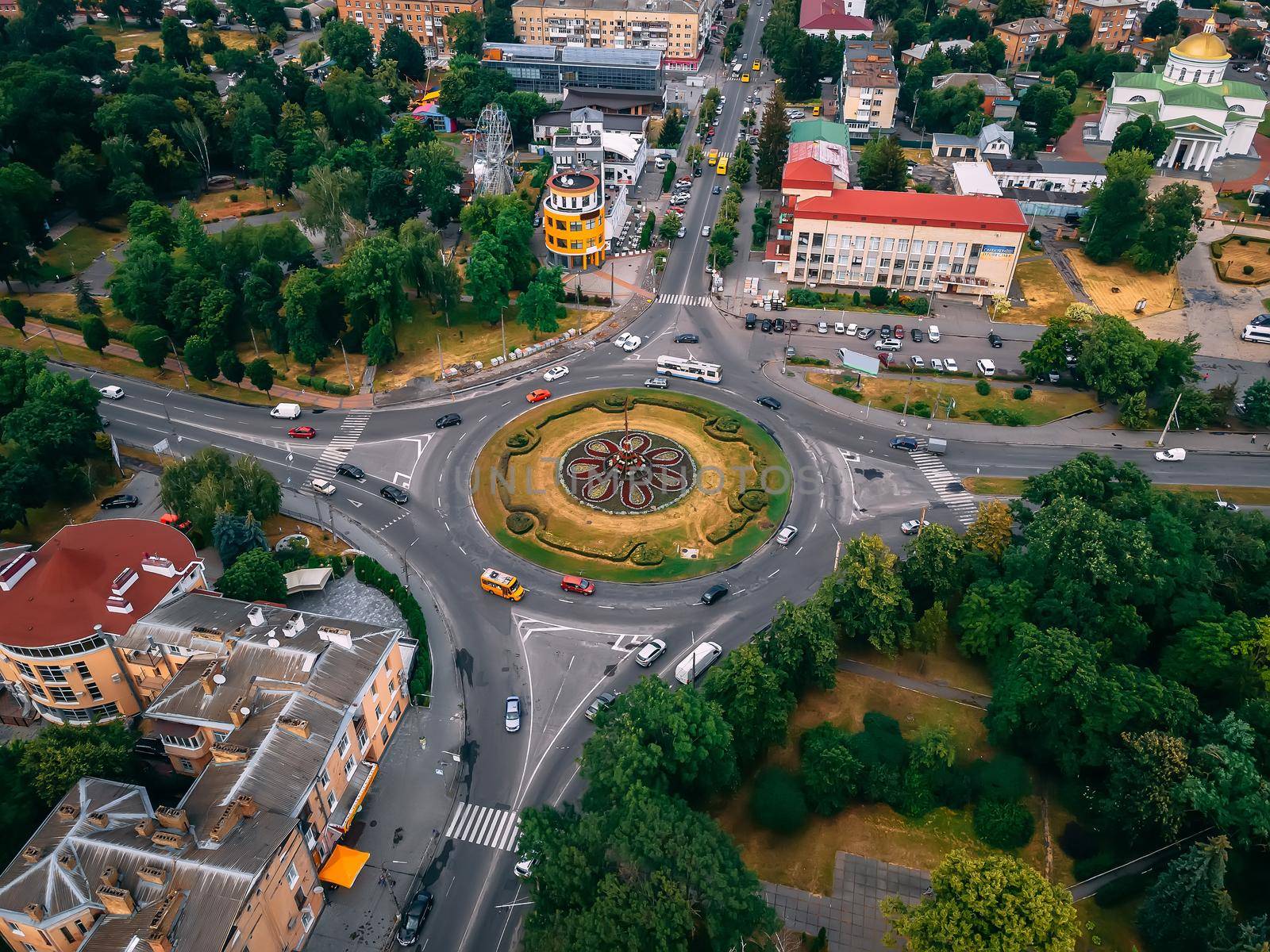 Aerial view of roundabout road with circular cars in small european city at summer afternoon, Kyiv region, Ukraine