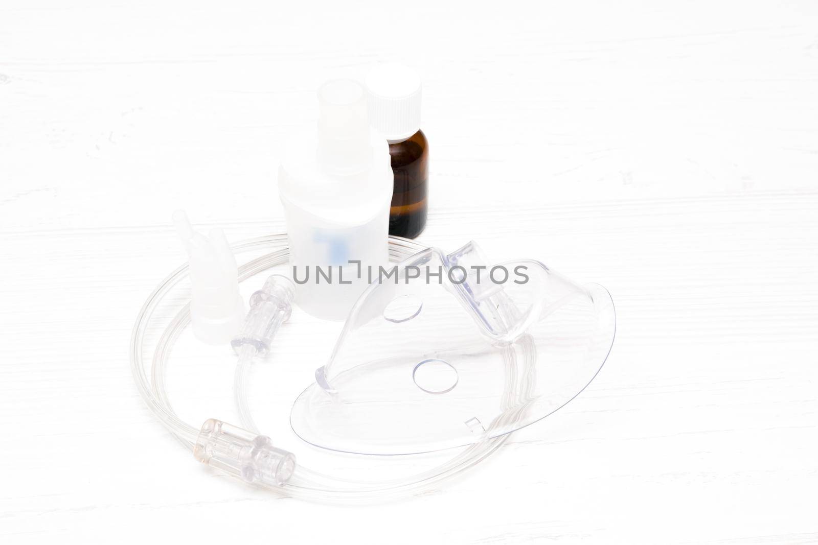 nhaler, tube and mask on a light background, copy space, medicine in a dark bottle for inhalation, respiratory diseases concept