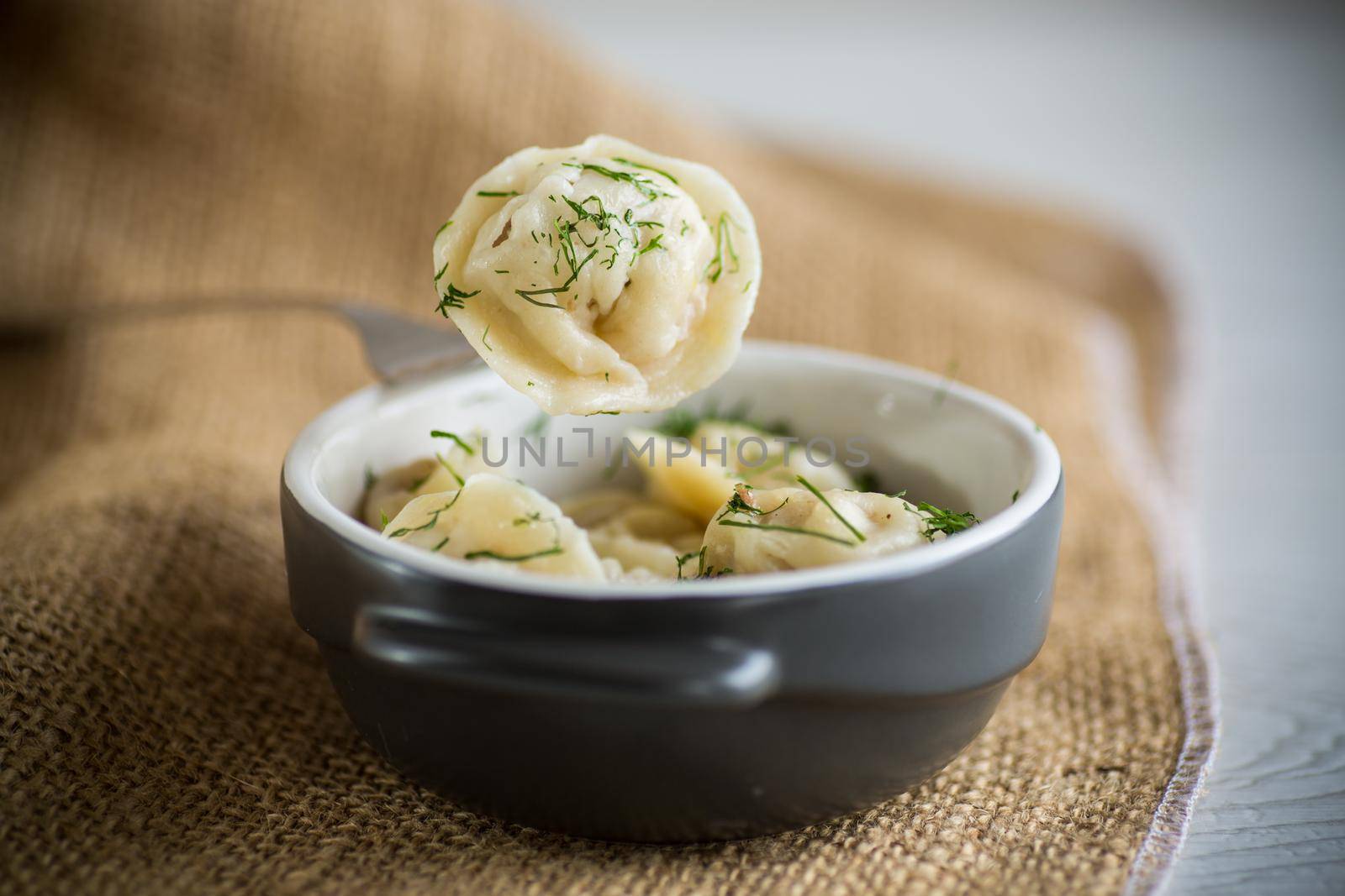 boiled dumplings with meat filling in a bowl on the table