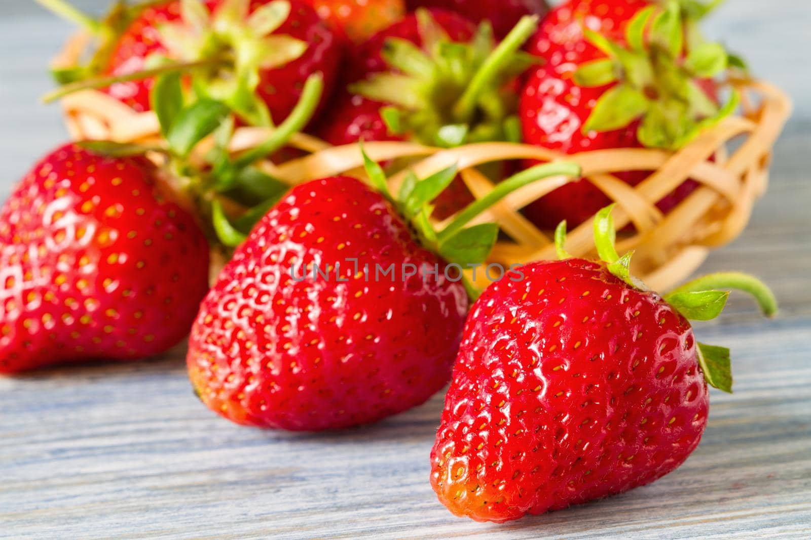 Fresh ripe strawberries on the blue wooden background. Selective focus. Closeup.