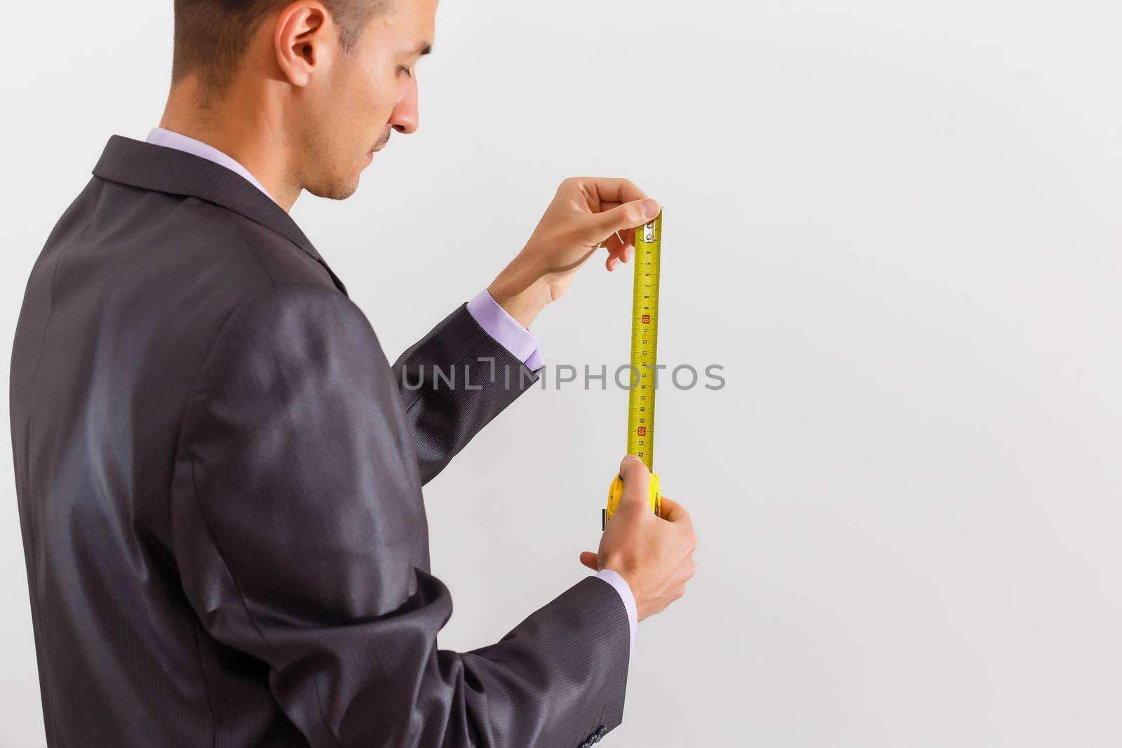 Businessman holding measurement tape, isolated on white background