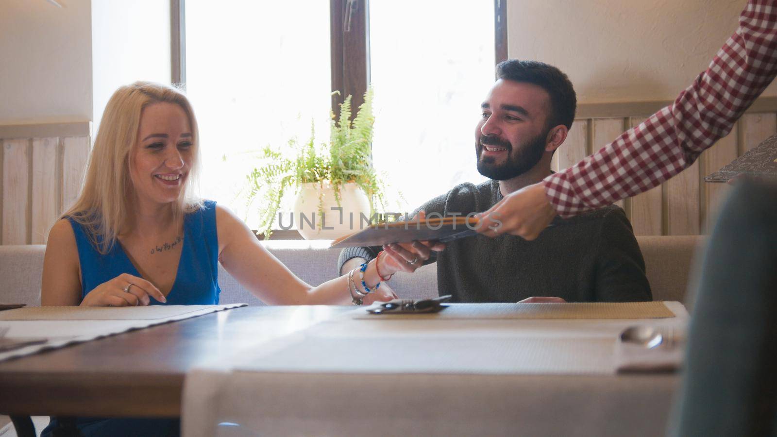 Happy caucasian couple takes the menu at the cafe, close up