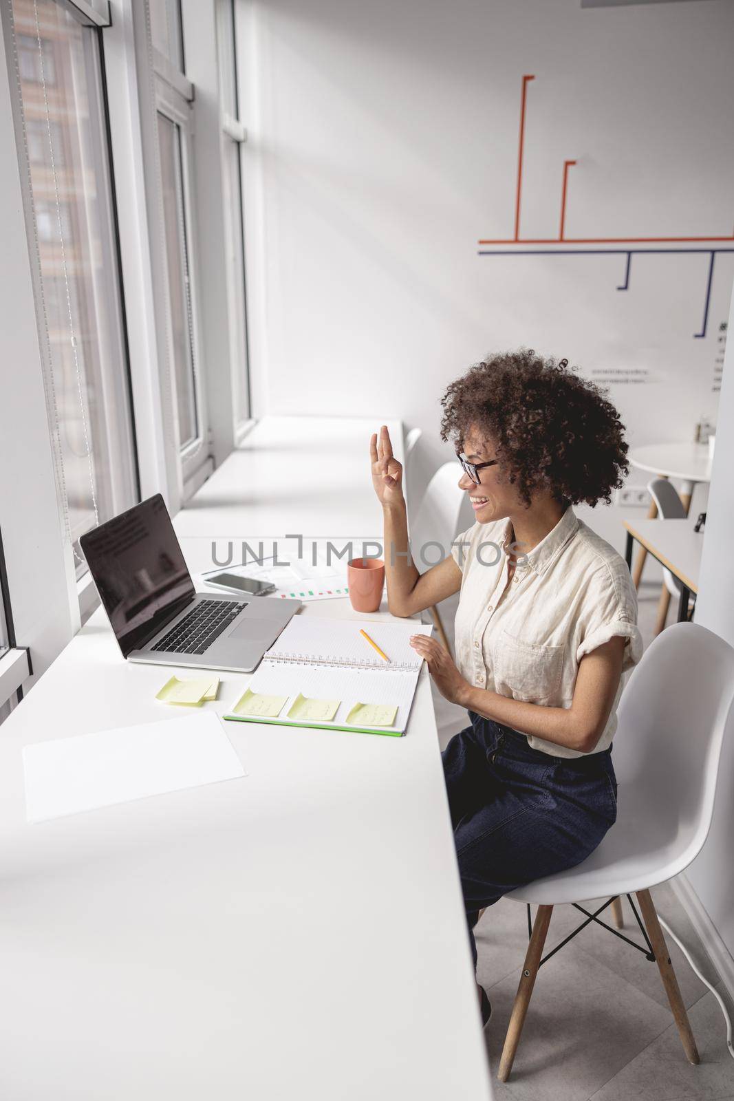 Woman communicating in sign language online at a laptop by Yaroslav_astakhov