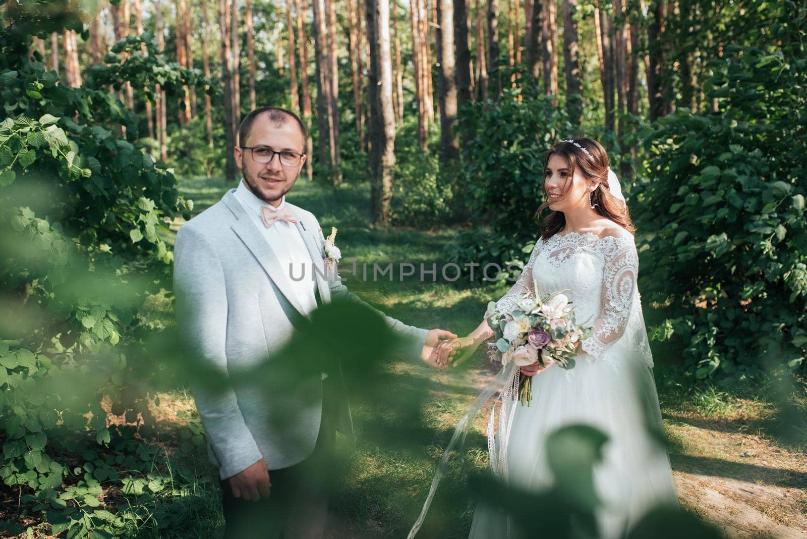 Wedding photo of the bride and groom in a gray-pink color on nature in the forest and rocks