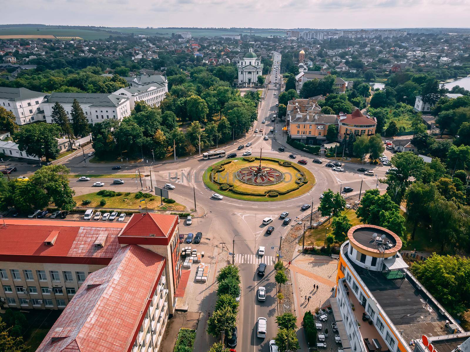 Aerial view of roundabout road with circular cars in small european city at summer afternoon, Kyiv region, Ukraine