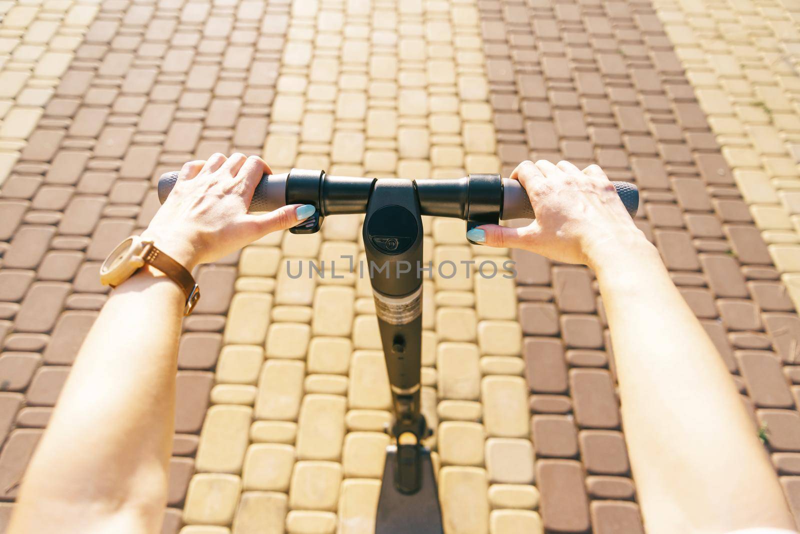 Woman riding an electric scooter in street, point of view. by alexAleksei