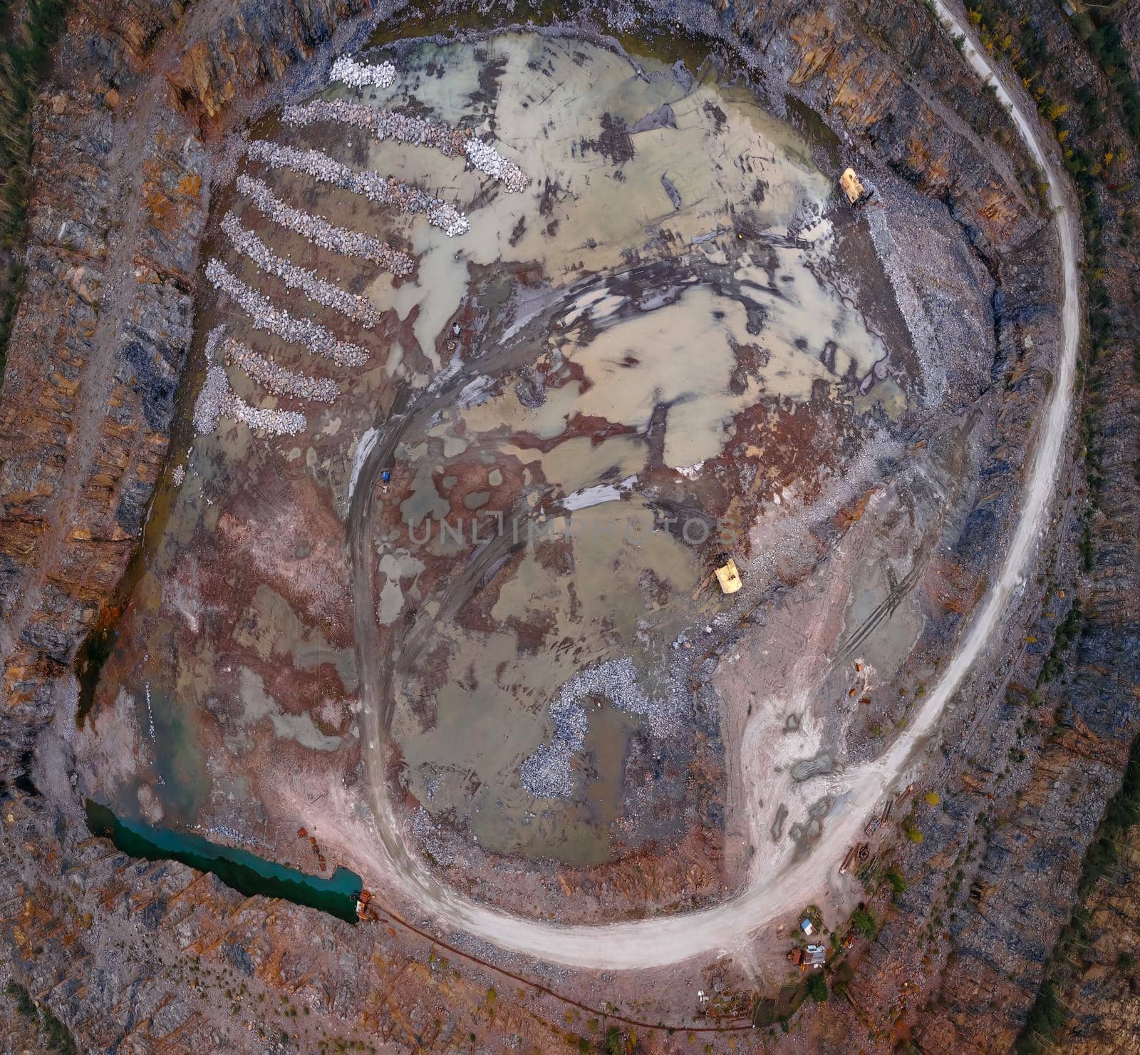 Aerial drone view of career in Europe at summer sunset, crushed stone quarry, beautiful nature round, some excavators, diggers inside