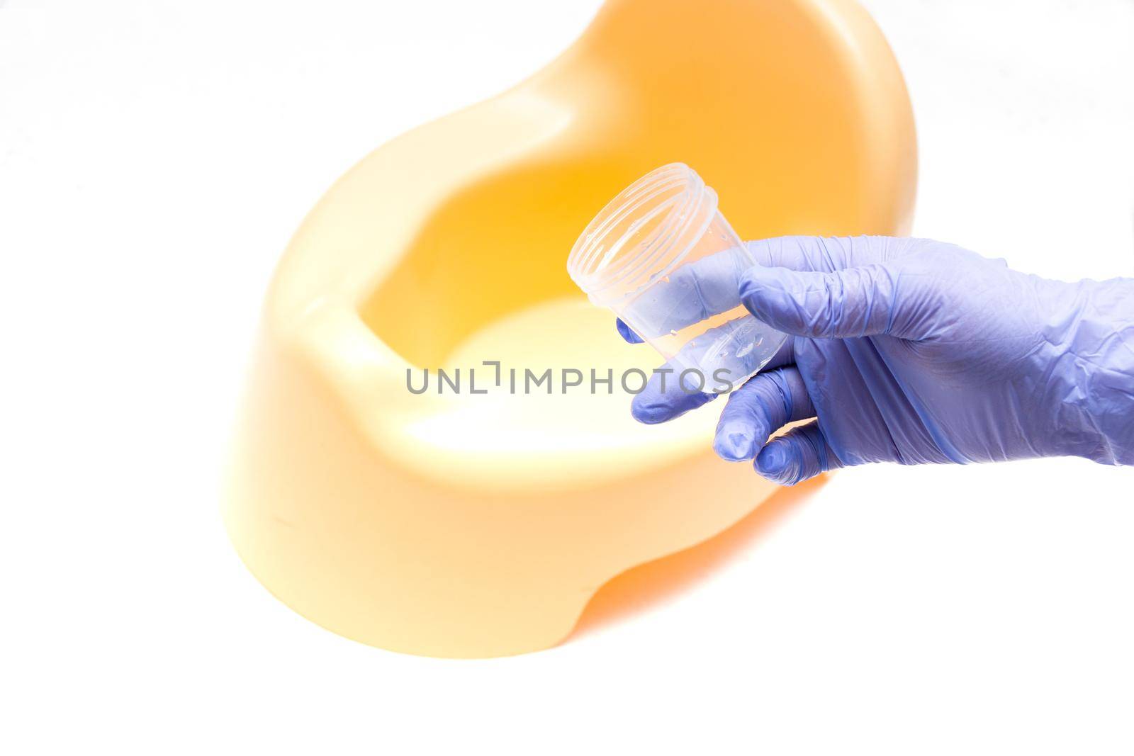 female hand with a blue disposable medical glove jerks a jar for analysis against the background of a yellow child pot, collecting urine clinical diagnosis, copy location, light background