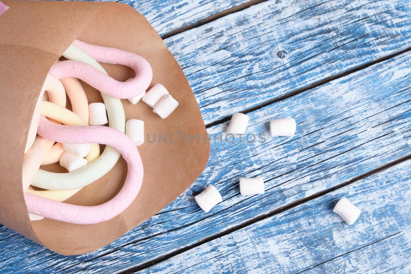 marshmallows wrapped in paper on blue wooden background