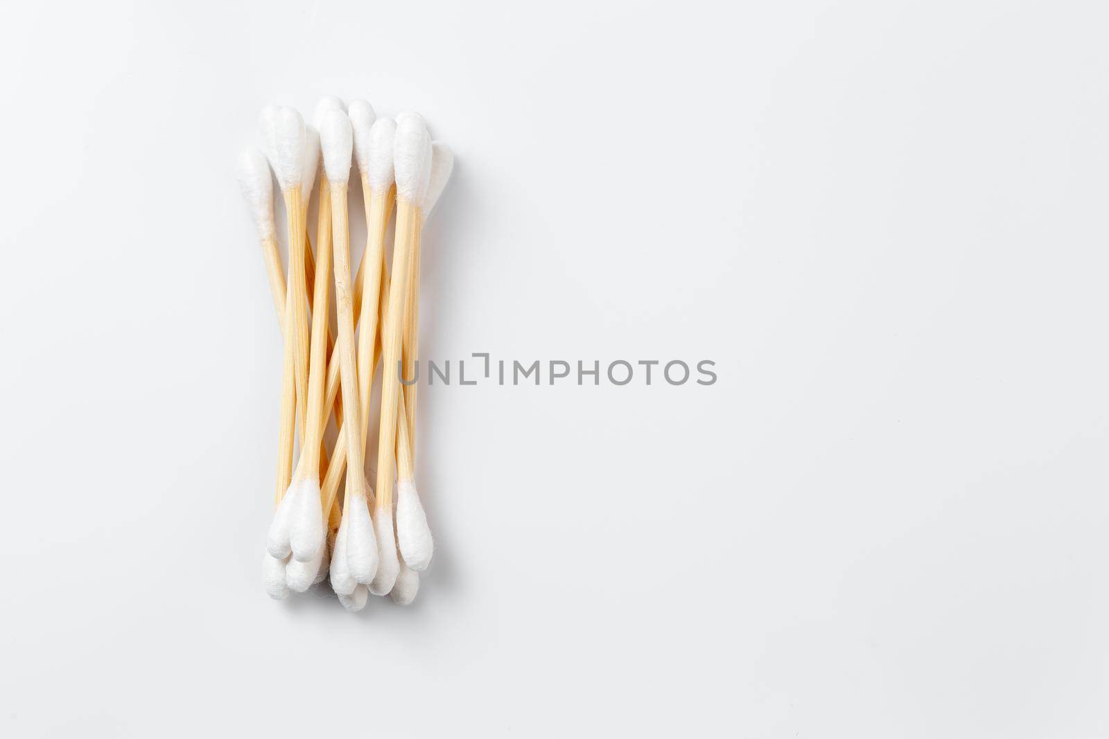 Bamboo cotton ear swabs on white background with copy space. Zero waste hygienic accessory product concept.