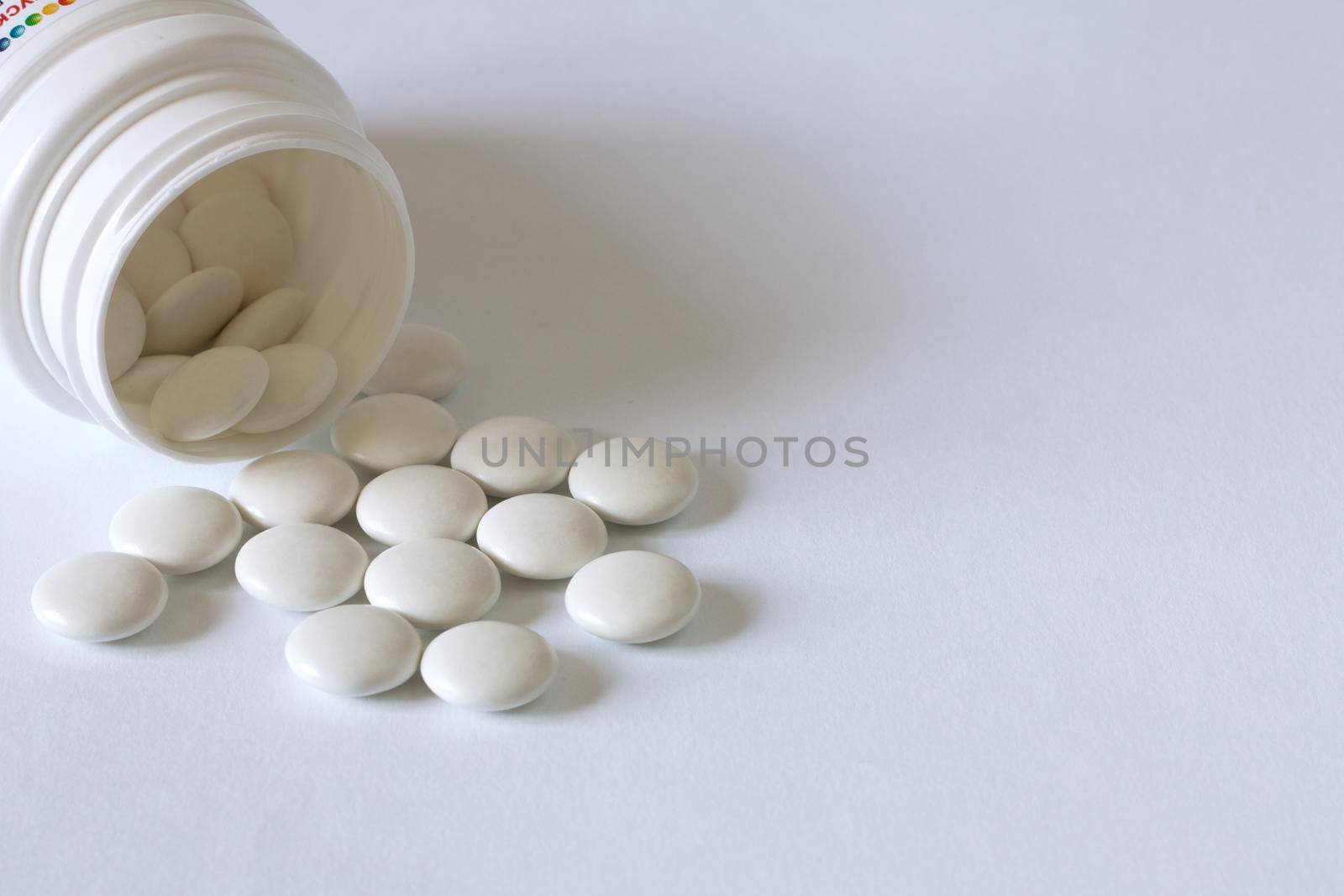 Pills from a jar on a light background