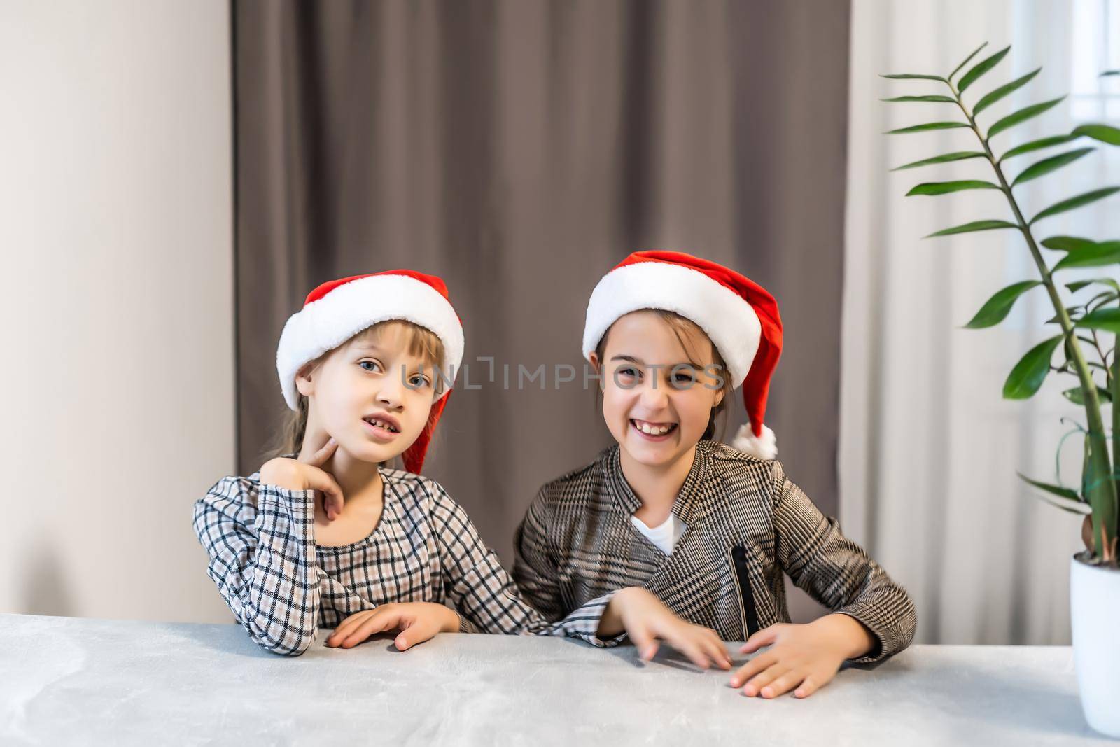 Christmas Happy funny children twins sisters in santa hats by Andelov13