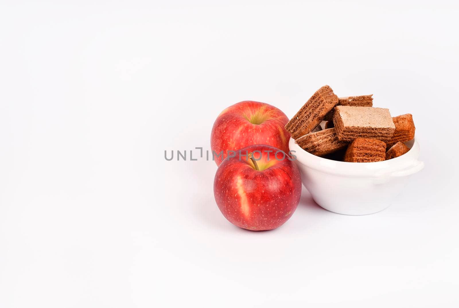 Apple pastila isolated on white background. Healthy snack concept. Pastila in a white bowl and red apple isolated.