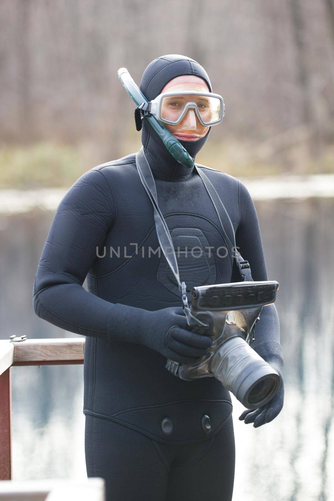 fisherman in wetsuit with photo camera in hands in preparation for a hunt by Studia72