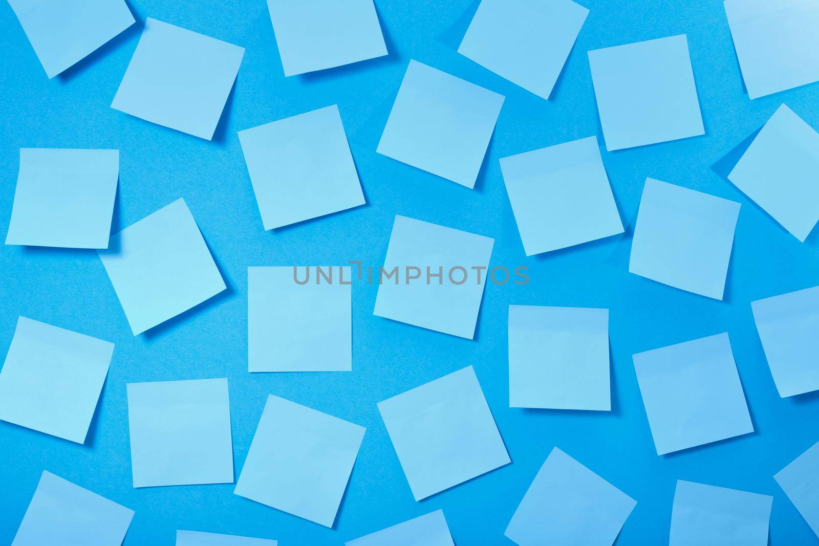 a lot of light blue paper stickers on a blue background, a pattern of stickers for notes, mock up
