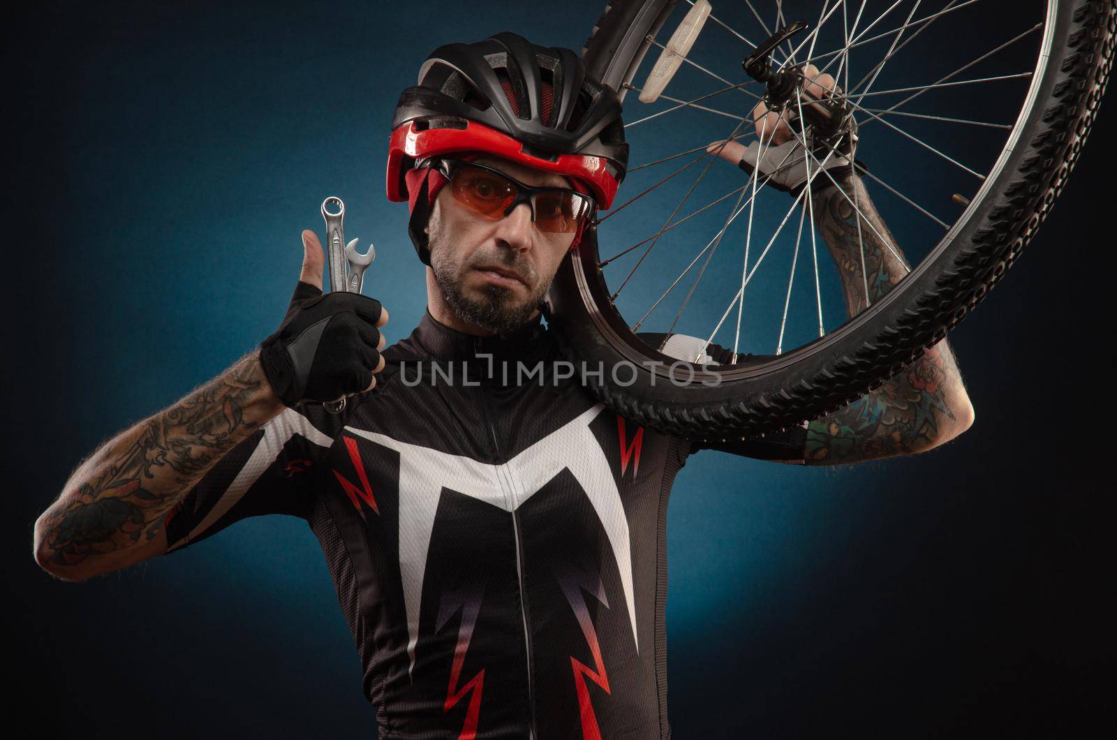 a guy-cyclist in a Bicycle helmet with a Bicycle wheel