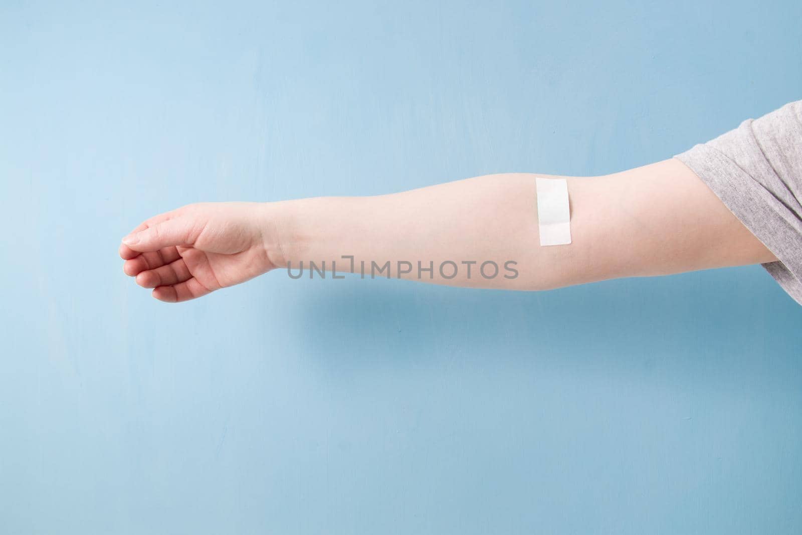 female hand with patch glued with a cross, heart on a patch, blood donor concept