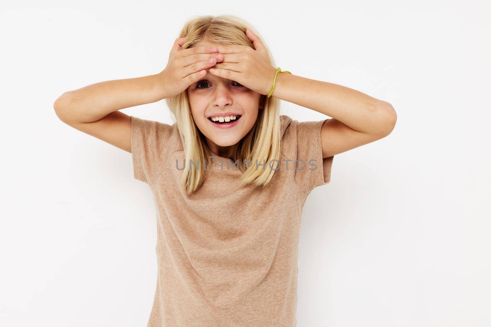 Portrait of a smiling little cutie in a beige t-shirt posing studio. High quality photo