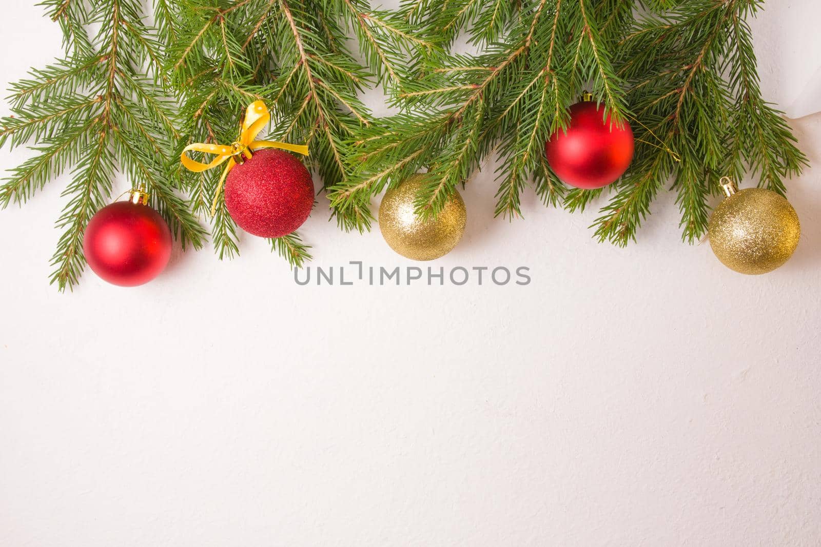 Christmas balls of gold and red colors and fir branches from above on a white background top view copy space, frame made of fresh natural fir branches by natashko