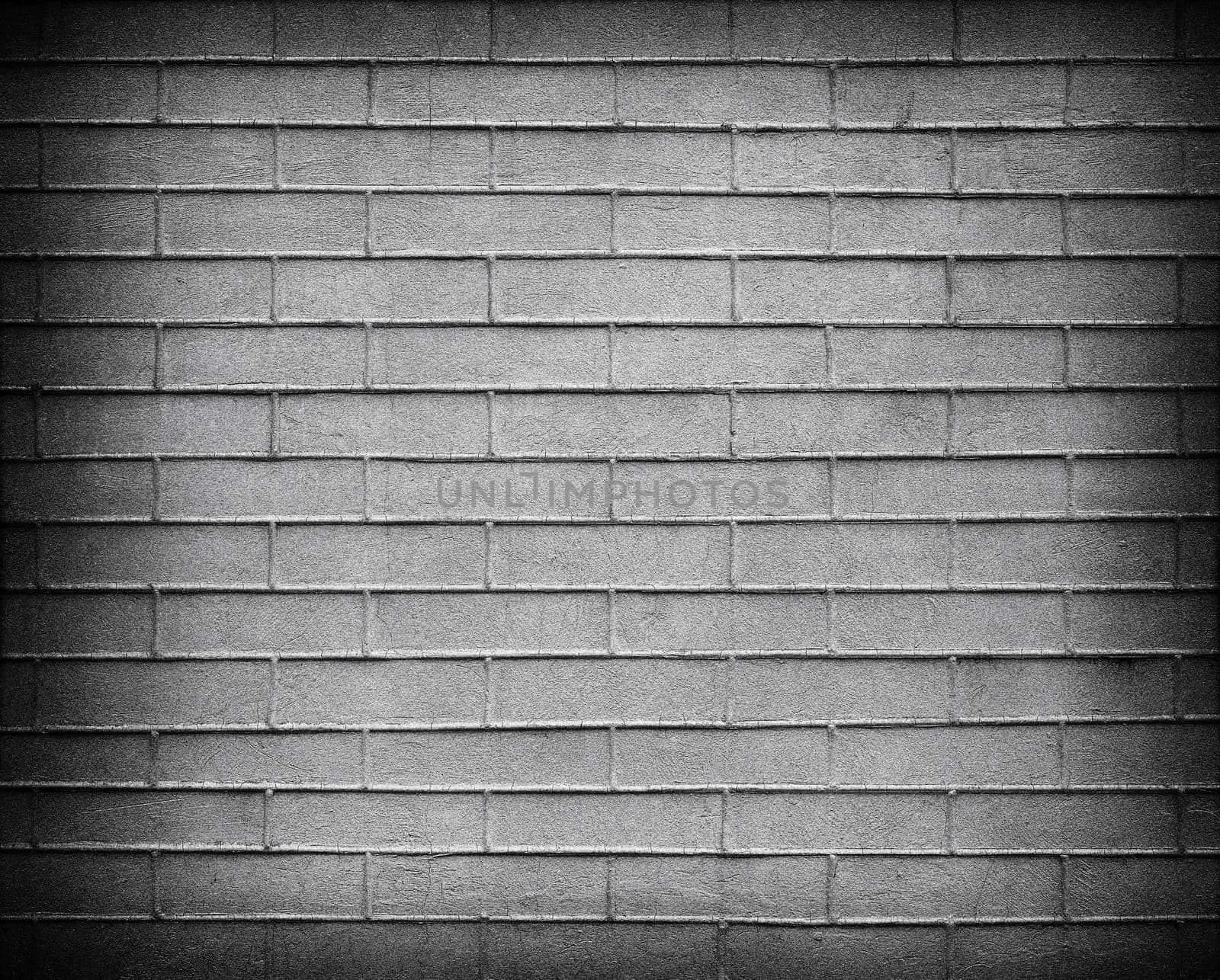 Gray Brick wall with darkened edges . Top view. Modern brick wall wallpaper design for web or graphic art projects. Abstract background for business cards and covers. Template or mock up.