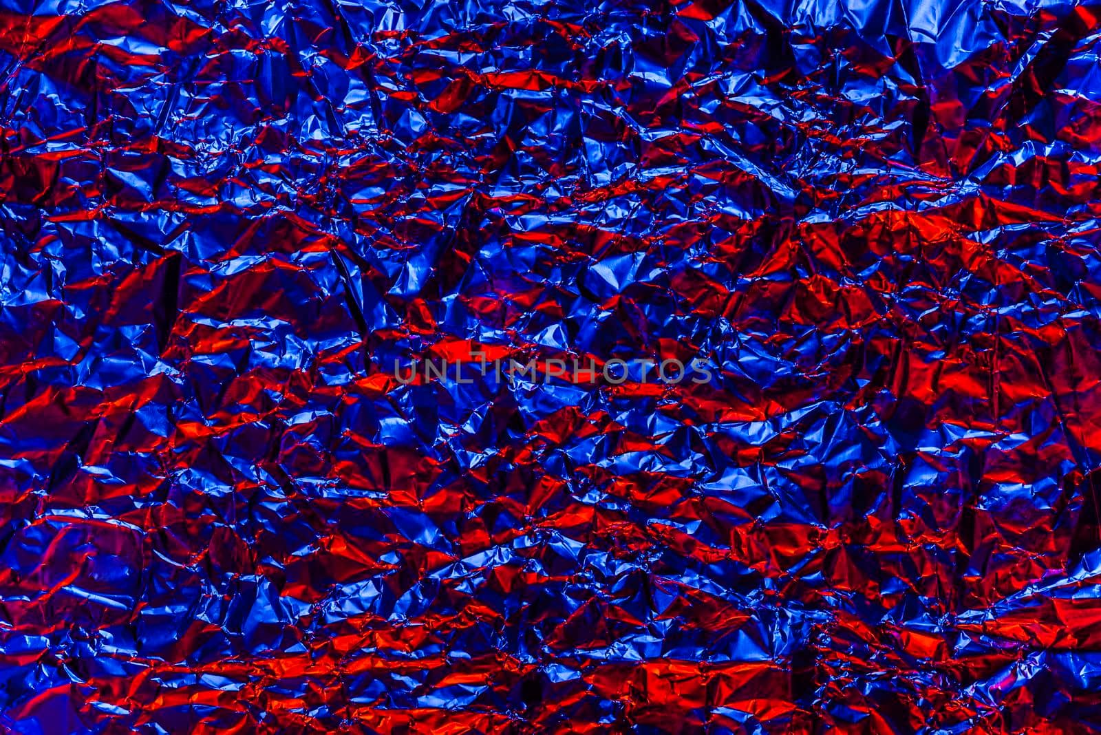 Red and blue foil background with shiny crumpled surface for texture background. Iridescent surface wrinkled foil by esvetleishaya