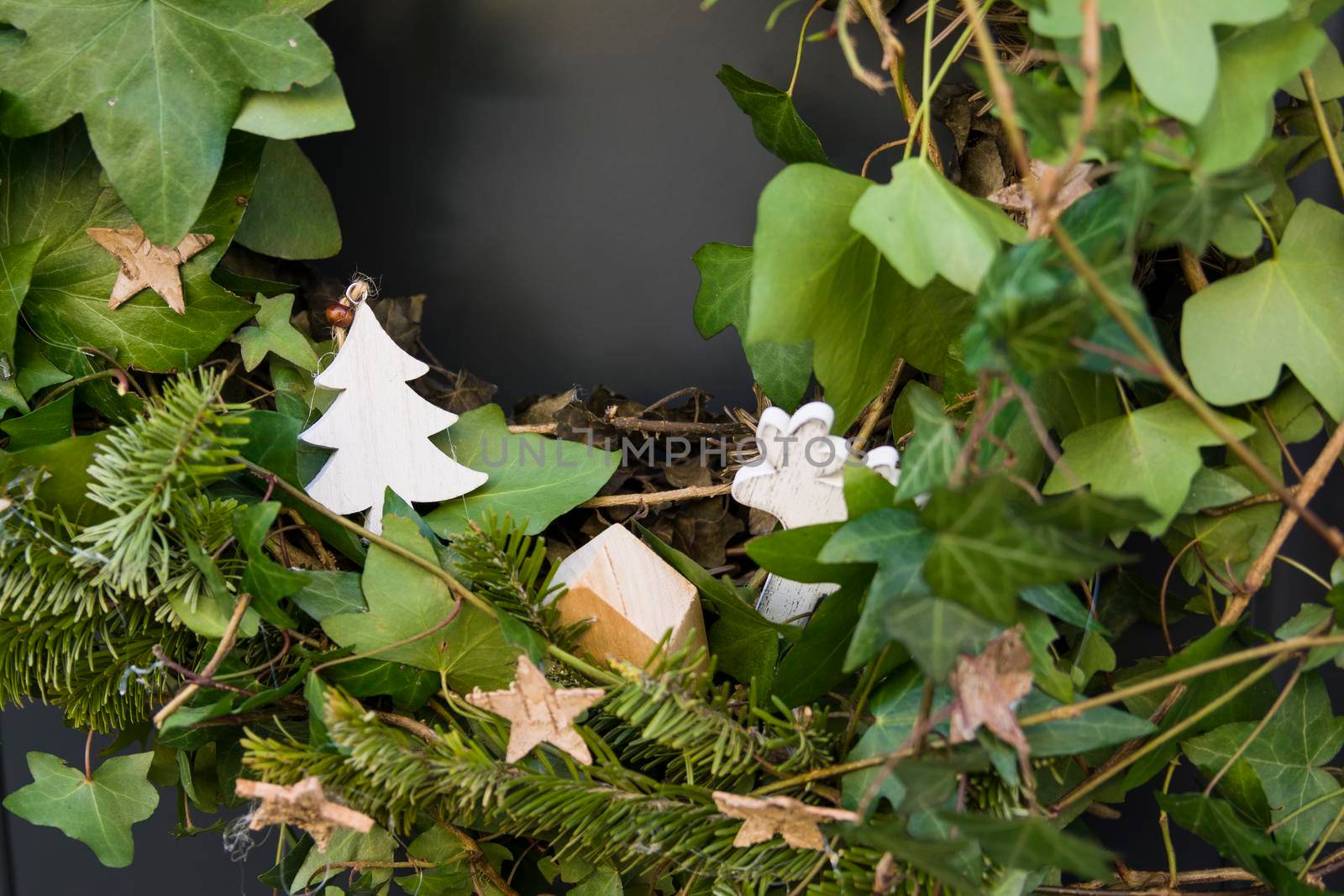 Front door with a Christmas wreath of ivy and bows.