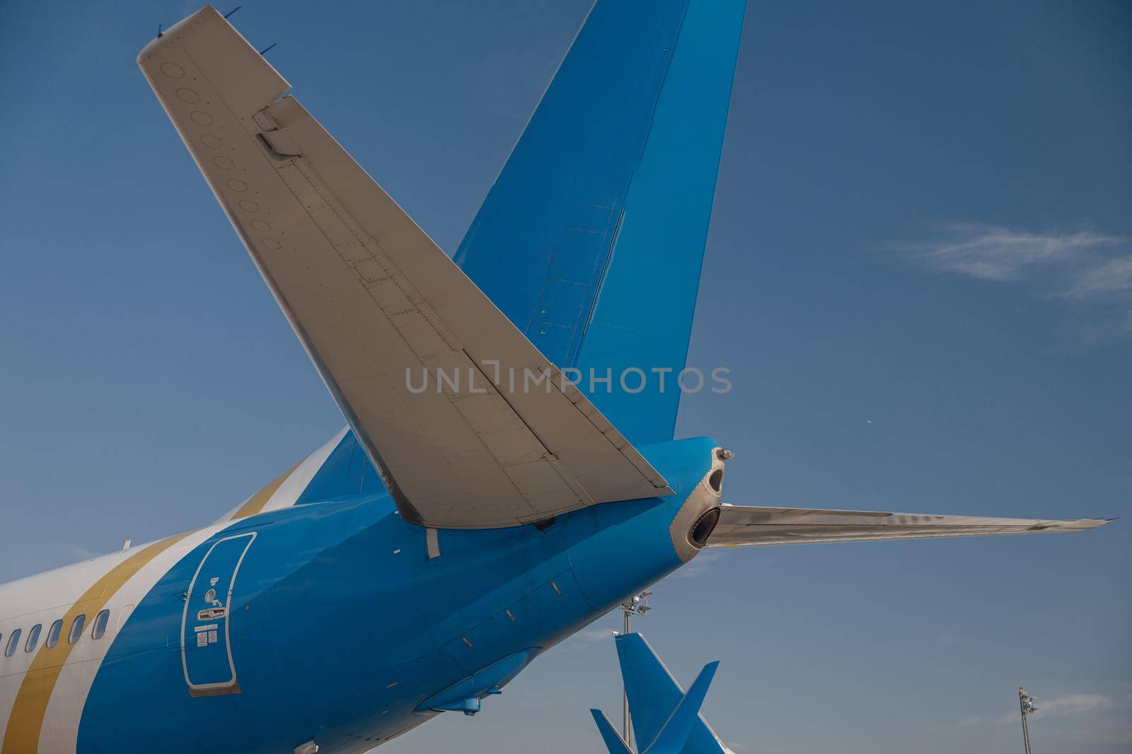 Tail of an aircraft in airport with blue sky in the background. Plane, transportation concept