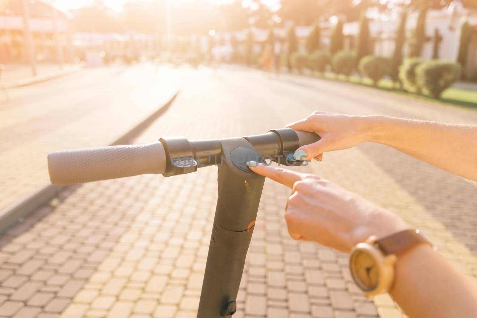 View of female hand turning on or off the electric scooter. by alexAleksei