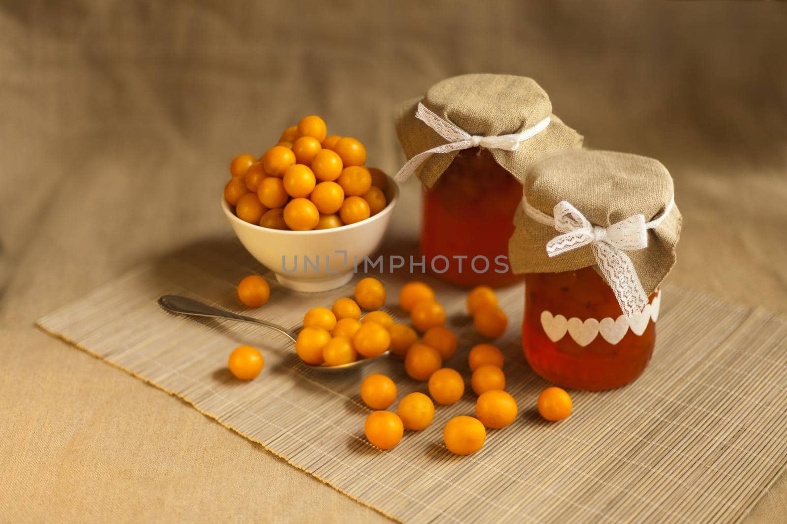 cherry plums yellow Jam, fresh vitamins-berries fruits. homemade marmalade in glass jar on brown textile background