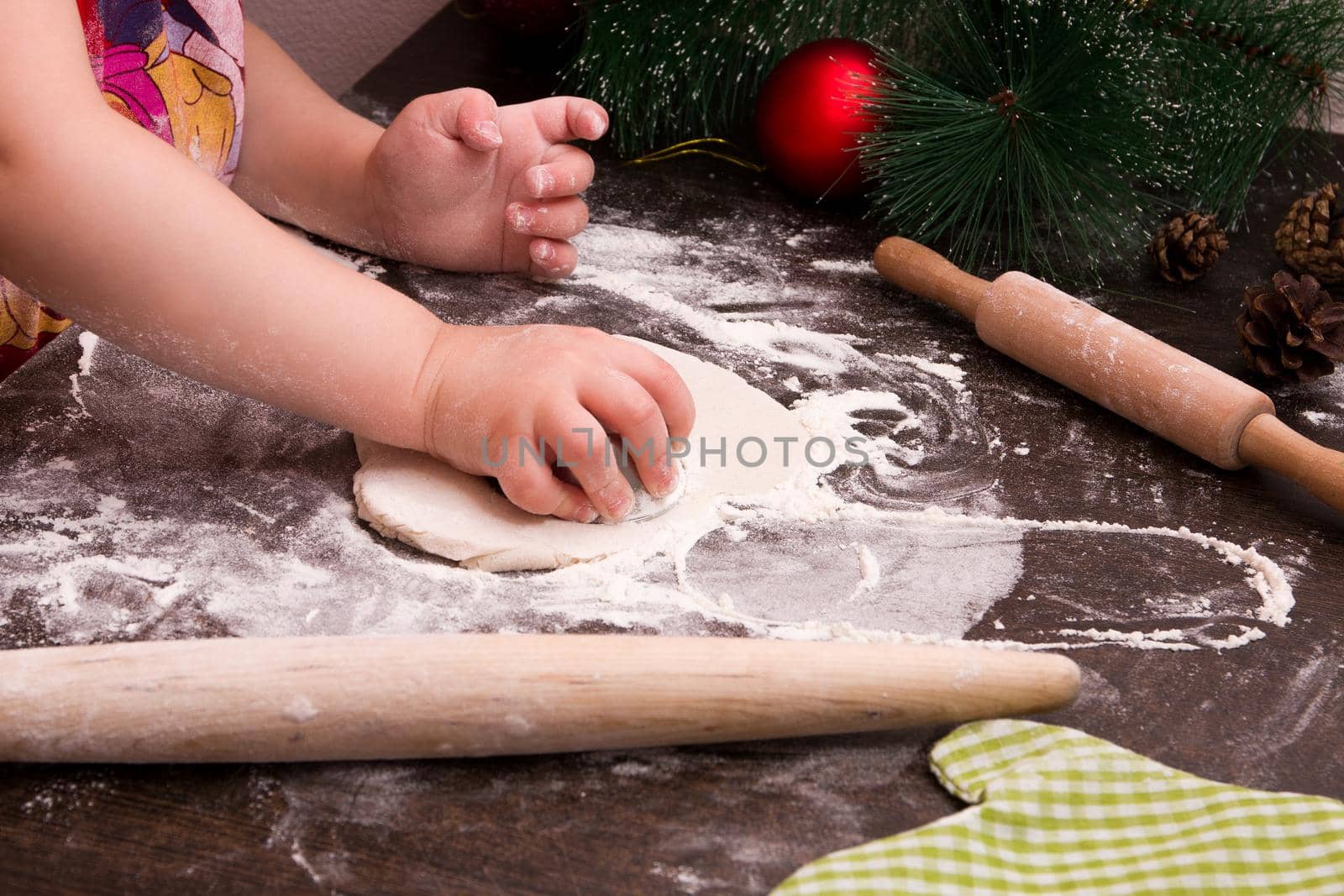 little girl makes christmas cookies, christmas background, bright colors, red christmas tree decorations, copy space