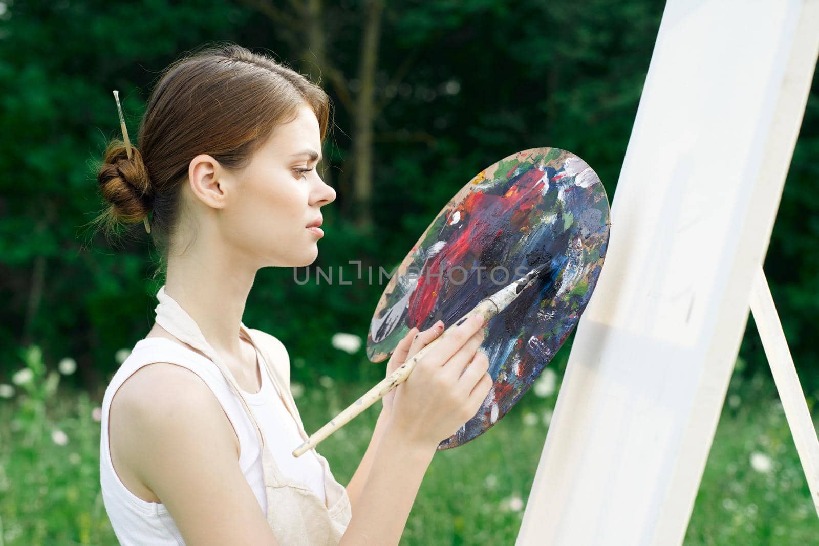 woman artist paints palette easel nature drawing by Vichizh