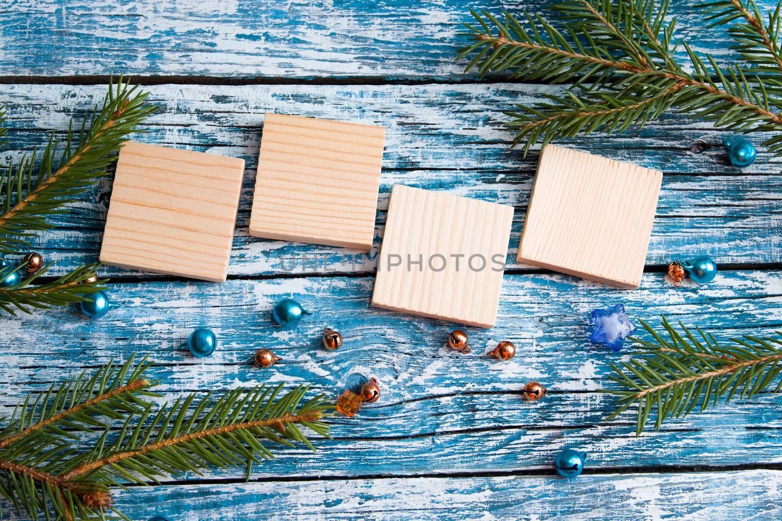 wooden squares for text, new year 2020, spruce branch, shiny beads, blue wooden background by natashko