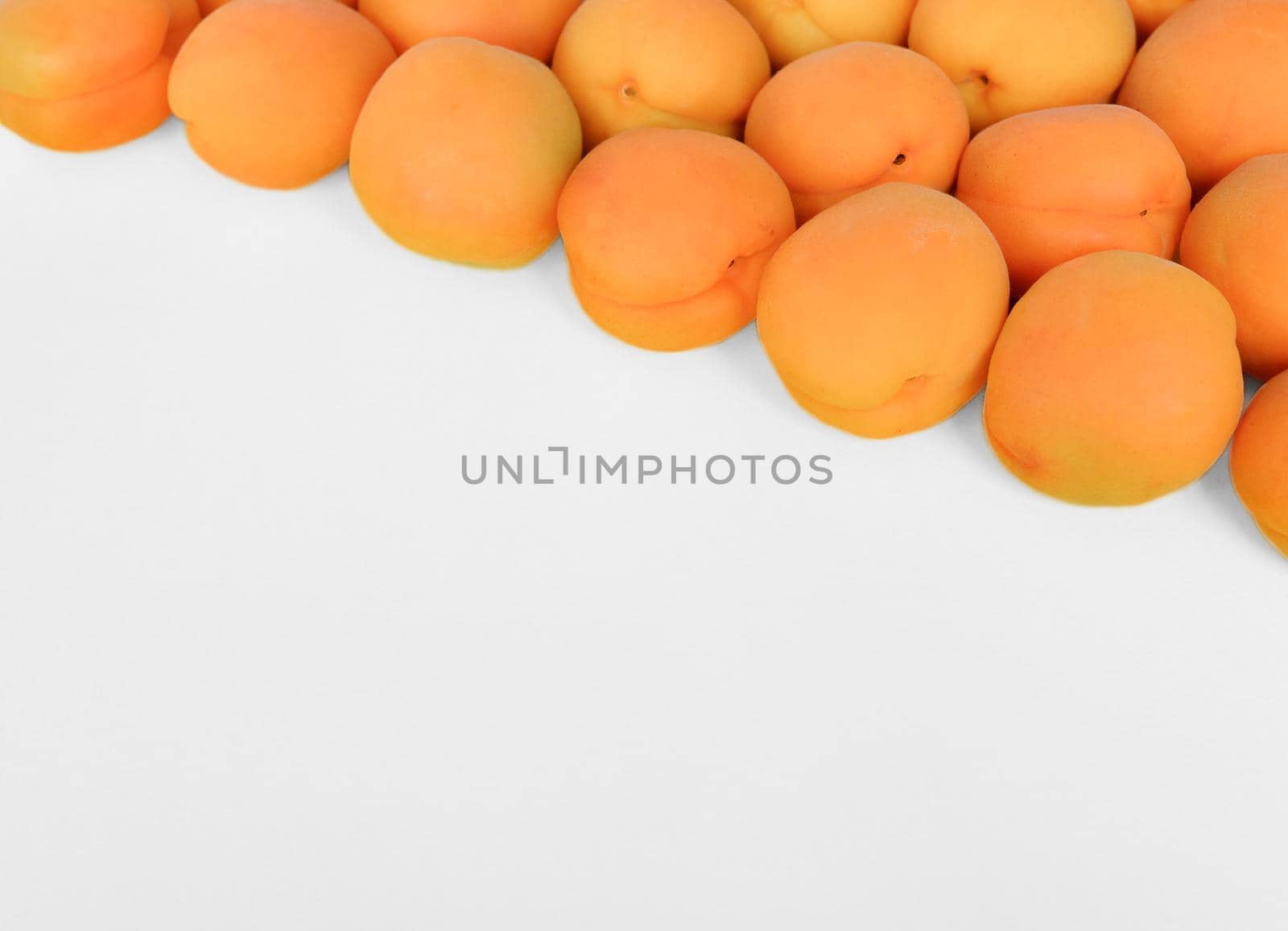 Apricot on a white background, arranged on top right corner, with copy space. Top view, close up.