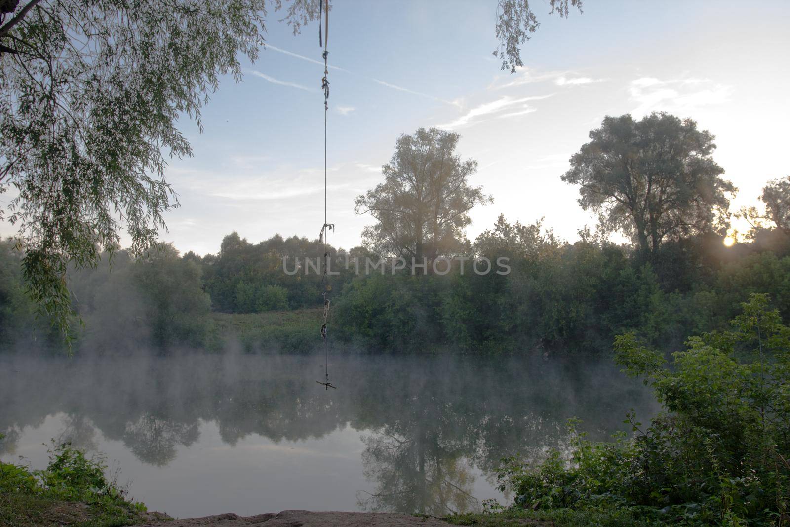Beautiful landscape. Clear lake at morning fog. Forest