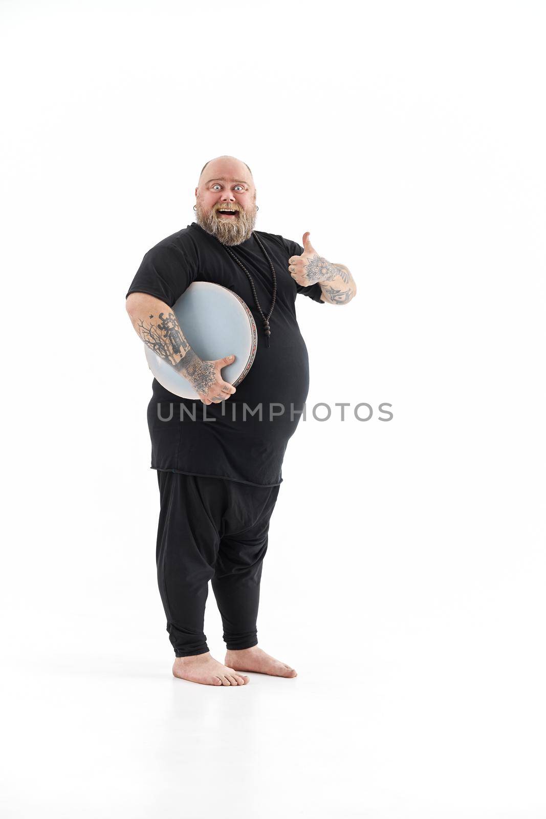 Funn caucasian bearded tattoed man is posing on white background