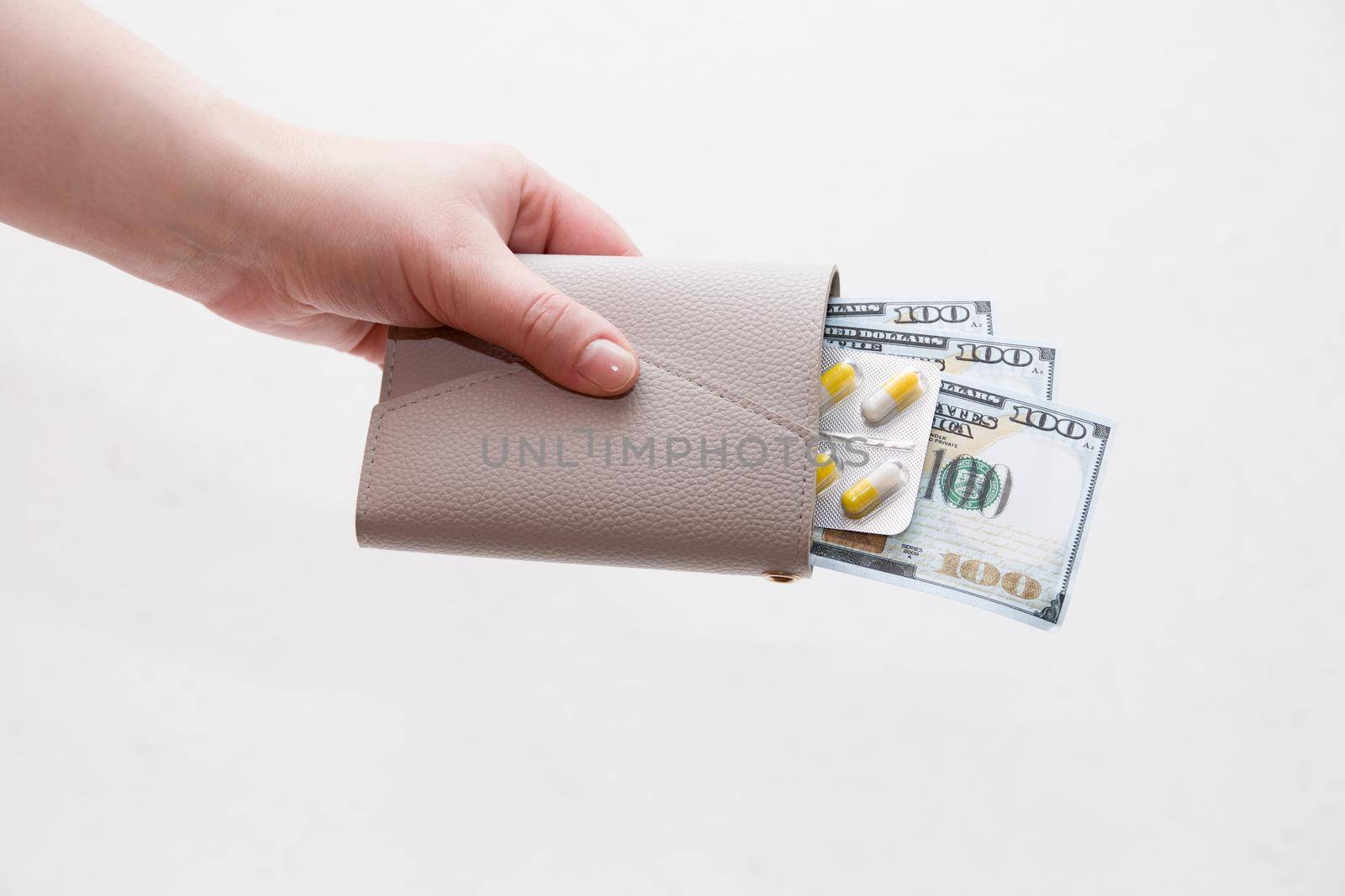 female hands open a wallet with pills, instead of money pills, white background by natashko