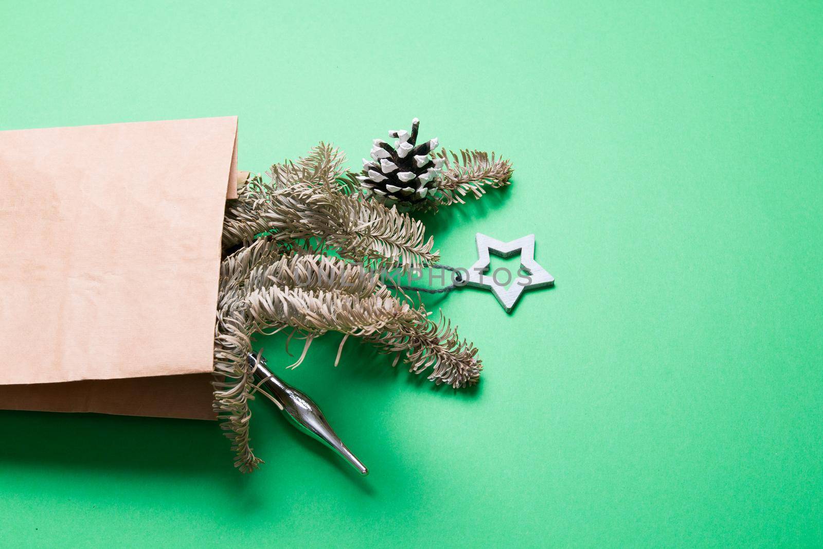 bouquet decorated with pine cones and Christmas toys, green background copy space