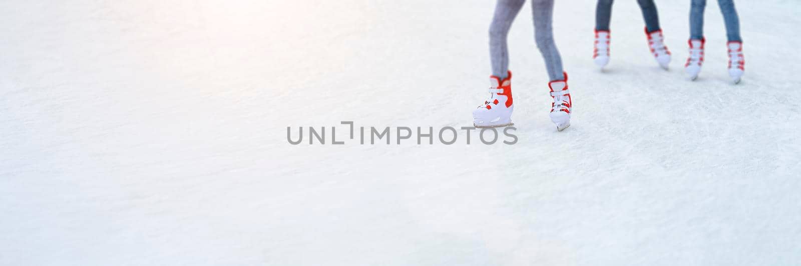 Legs skating on ice. Long banner with copy space. People go ice skating in rented skates. Winter sports concept by esvetleishaya