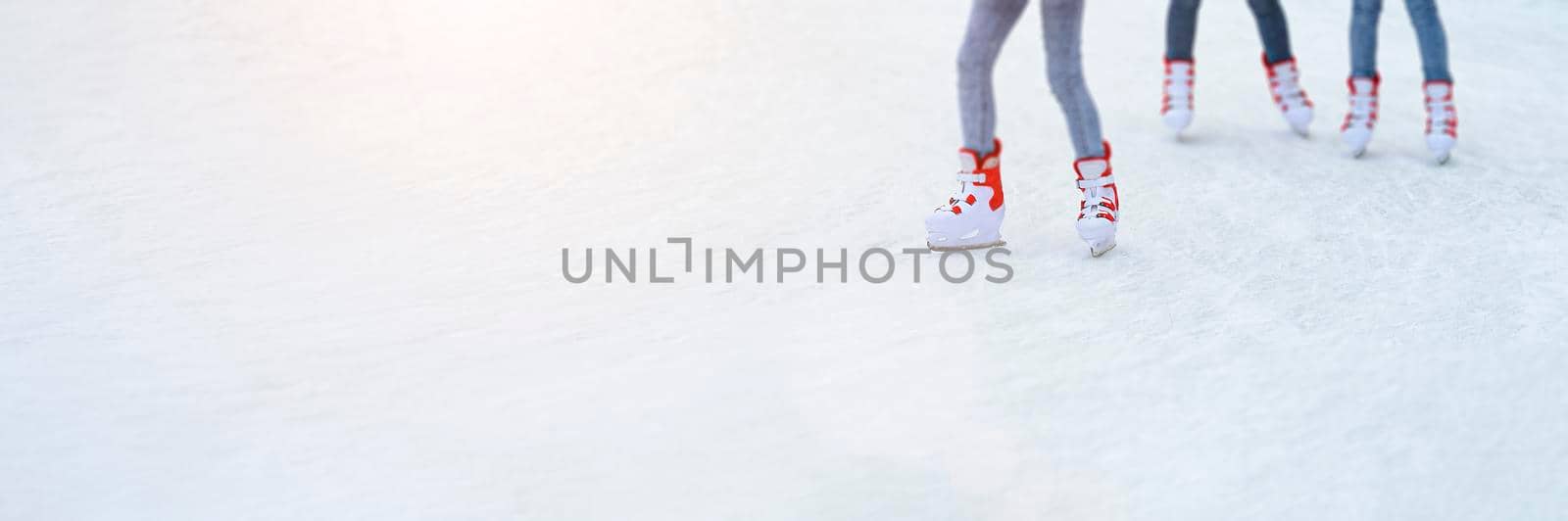 Legs skating on ice. Long banner with copy space. People go ice skating in rented skates. Winter sports concept.