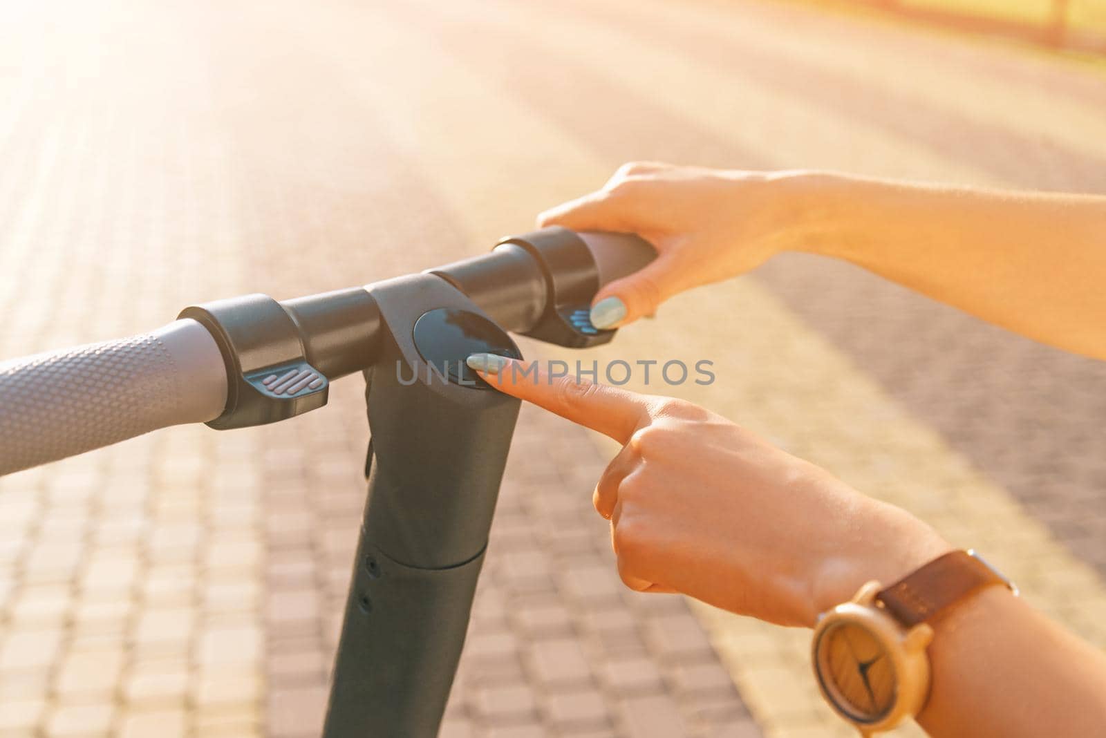 Woman turning on or off the electric scooter in street. by alexAleksei